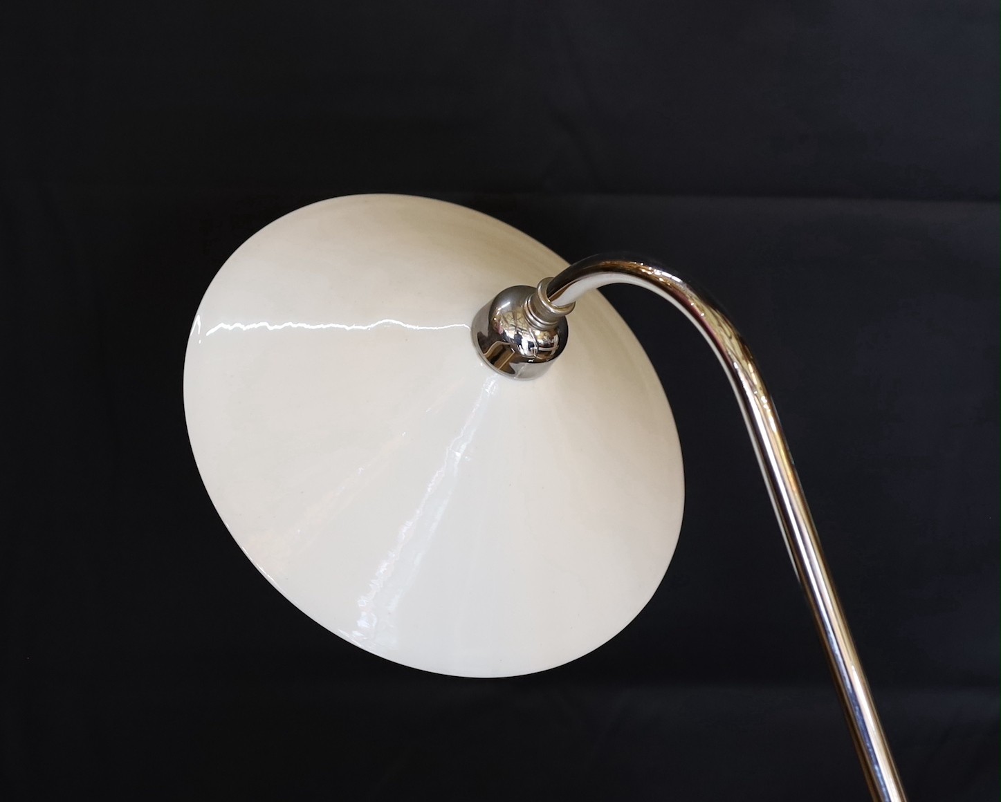 A stylish nickel plated desk lamp, with conical opaque white glass shade and loaded spherical base, height 52cm